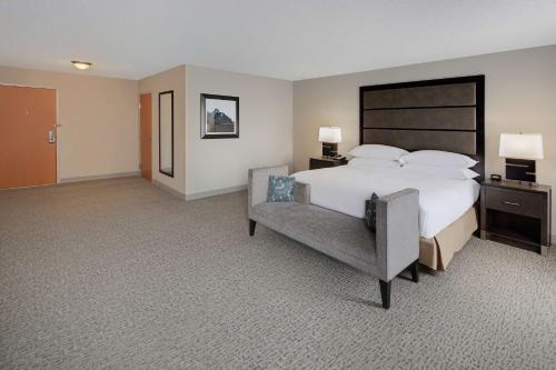 a large hotel room with a bed and a chair at DoubleTree Richmond Airport in Sandston