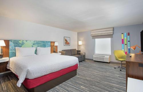 um quarto de hotel com uma cama e uma televisão em Hampton Inn Simpsonville em Simpsonville