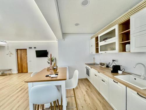 奧托佩尼的住宿－Residence Odaile #6，厨房配有白色橱柜和桌椅