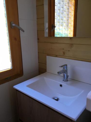uma casa de banho com um lavatório branco e um espelho. em CHALET MARYVONNE em Les Vans