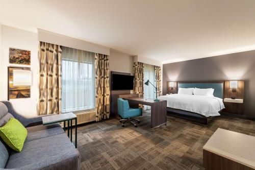 pokój hotelowy z łóżkiem i kanapą w obiekcie Hampton Inn & Suites Snellville Atlanta Ne w mieście Snellville