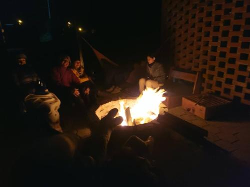 a group of people sitting around a fire pit at night at El Chasqui Guest House in Chasqui