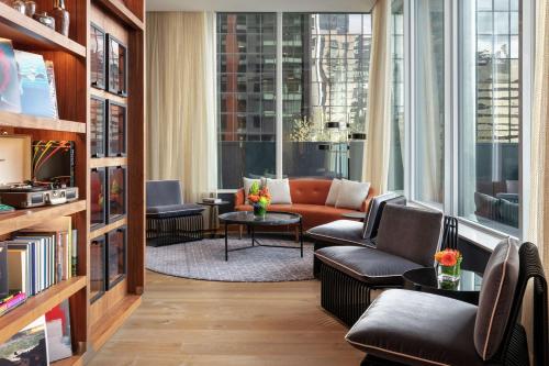 a living room with a couch and chairs and windows at The Sound Hotel Seattle Belltown, Tapestry Collection in Seattle