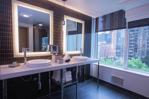 a bathroom with two sinks and a large window at The Sound Hotel Seattle Belltown, Tapestry Collection in Seattle