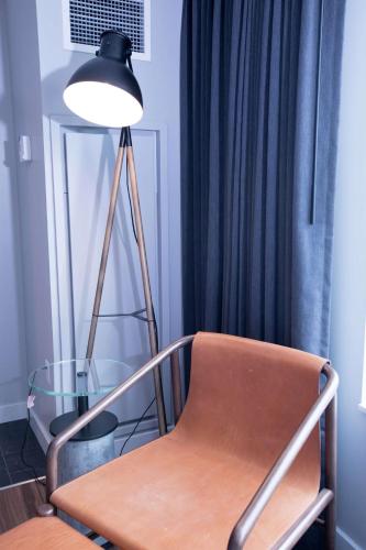 a lamp and a chair in a room with a window at The Sound Hotel Seattle Belltown, Tapestry Collection in Seattle