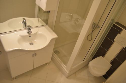 a bathroom with a sink and a shower and a toilet at Apartments Soldo in Baška