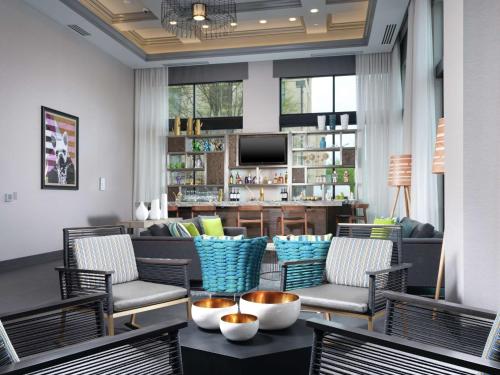 a living room with chairs and a couch and a television at Hampton Inn & Suites Atlanta Decatur/Emory in Decatur