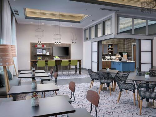 a restaurant with tables and chairs and a kitchen at Hampton Inn & Suites Atlanta Decatur/Emory in Decatur