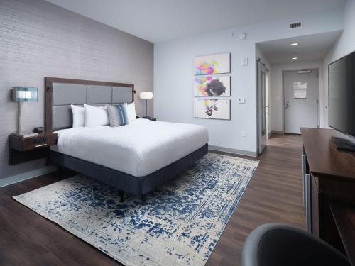 Habitación de hotel con cama, escritorio y TV. en Hampton Inn & Suites Atlanta Decatur/Emory, en Decatur