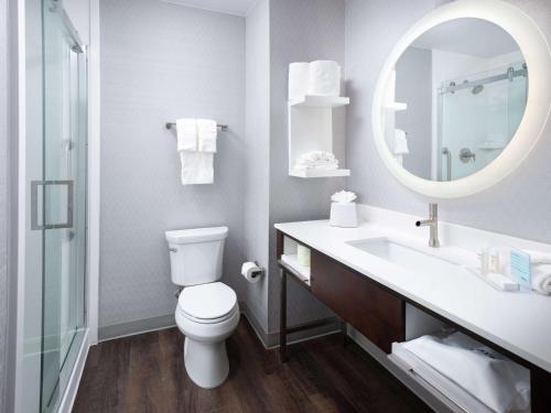 a bathroom with a toilet and a sink and a mirror at Hampton Inn & Suites Atlanta Decatur/Emory in Decatur