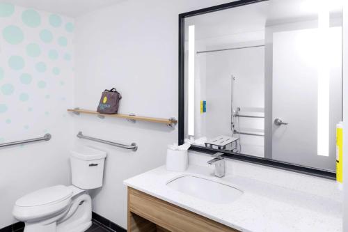 bagno con servizi igienici, lavandino e specchio di Tru By Hilton Gilbert a Gilbert