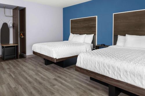 una camera d'albergo con due letti e pareti blu di Tru By Hilton Gilbert a Gilbert