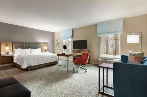 Hampton Inn And Suites By Hilton Johns Creek في جونز كريك: غرفه فندقيه بسرير ومكتب وكرسي