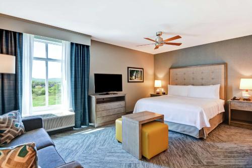 um quarto de hotel com uma cama e uma televisão em Homewood Suites By Hilton Hadley Amherst em Hadley