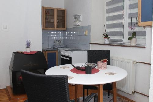 a small kitchen with a white table and chairs at Ema Apartman in Livno