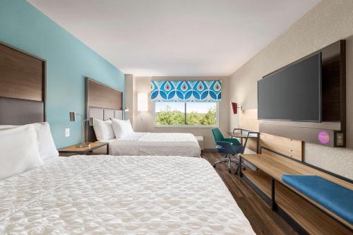 ein Hotelzimmer mit 2 Betten und einem Flachbild-TV in der Unterkunft Tru Lawrenceville Atlanta I85 Sugarloaf in Lawrenceville