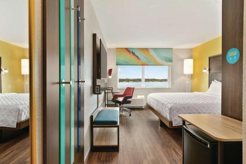 a hotel room with two beds and a desk at Tru By Hilton Sebring FL in Sebring