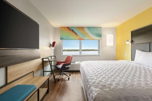 Habitación de hotel con cama, escritorio y TV. en Tru By Hilton Sebring FL, en Sebring
