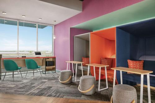 a room with colorful walls and tables and chairs at Tru By Hilton Sebring FL in Sebring