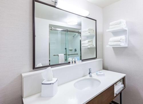 a bathroom with a sink and a large mirror at Hampton Inn Gardner in Gardner