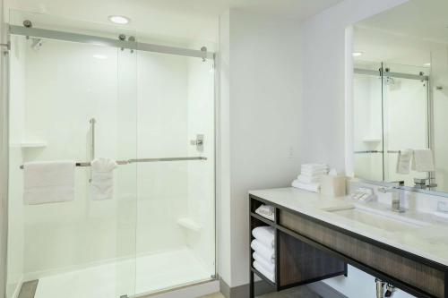 y baño con ducha acristalada y lavamanos. en Hilton Garden Inn Wenatchee, Wa en Wenatchee