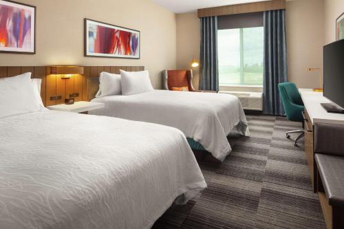 a hotel room with two beds and a television at Hilton Garden Inn Sacramento Airport Natomas in Sacramento