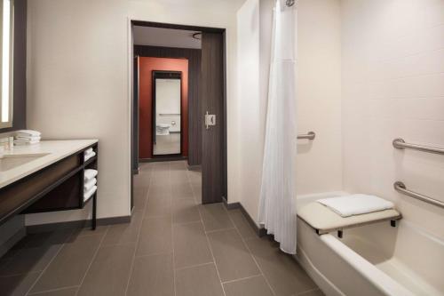 a bathroom with a tub and a toilet and a sink at Hilton Garden Inn Sacramento Airport Natomas in Sacramento