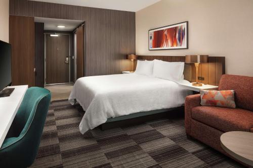 a hotel room with a large bed and a couch at Hilton Garden Inn Sacramento Airport Natomas in Sacramento