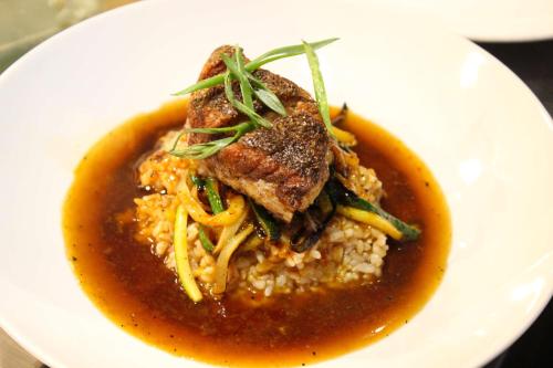a white plate of food with meat and sauce at Chrysalis Inn & Spa Bellingham, Curio Collection by Hilton in Bellingham