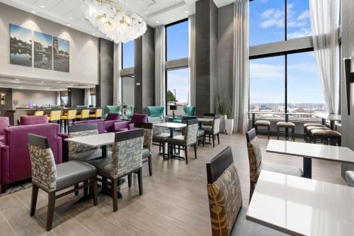 a restaurant with tables and chairs and windows at Hampton Inn & Suites Spokane Downtown-South in Spokane