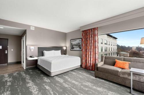 Hampton Inn & Suites Spokane Downtown-South في سبوكان: غرفه فندقيه بسرير واريكه