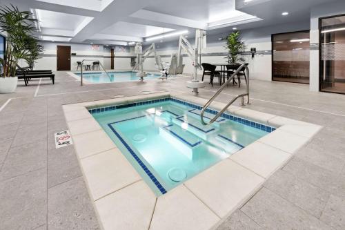 a large swimming pool in a lobby with tables and chairs at Hampton Inn & Suites Spokane Downtown-South in Spokane
