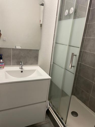 ein Bad mit einem Waschbecken und einer Dusche in der Unterkunft Plage des quilles in Sète