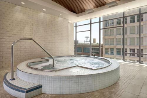 Homewood Suites By Hilton Chicago Downtown South Loop في شيكاغو: حوض استحمام ساخن في غرفة مع نافذة كبيرة