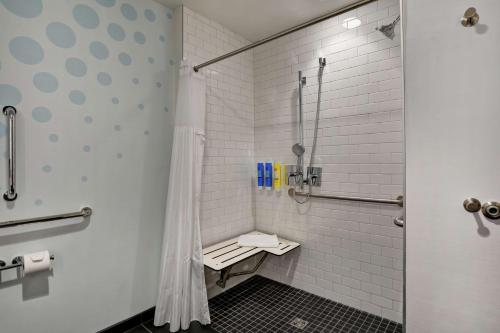 y baño con ducha y banco. en Tru By Hilton Idaho Falls Id, en Idaho Falls