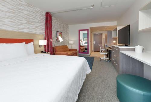 Home2 Suites By Hilton Yakima Airport في ياكيما: غرفة الفندق بسرير كبير ومكتب