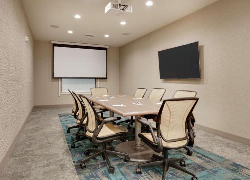 a conference room with a table and chairs and a screen at Home2 Suites By Hilton Yakima Airport in Yakima