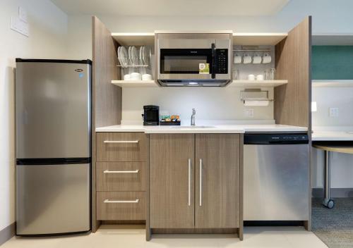 a kitchen with a refrigerator and a microwave at Home2 Suites By Hilton Yakima Airport in Yakima