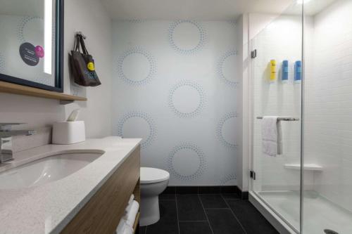 uma casa de banho com um WC e uma cabina de duche em vidro. em Tru By Hilton Seneca Clemson Sc em Seneca