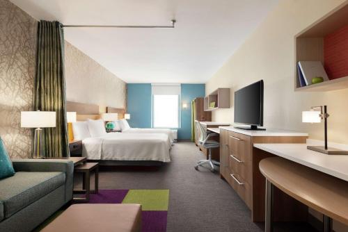 a hotel room with a bed and a tv at Home2 Suites By Hilton Overland Park, Ks in Overland Park