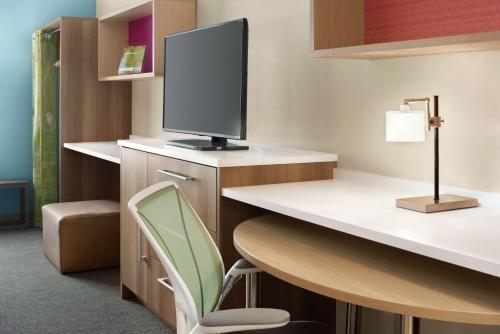 a room with a desk with a tv and a chair at Home2 Suites By Hilton Overland Park, Ks in Overland Park