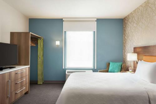 a hotel room with a bed and a television at Home2 Suites By Hilton Overland Park, Ks in Overland Park