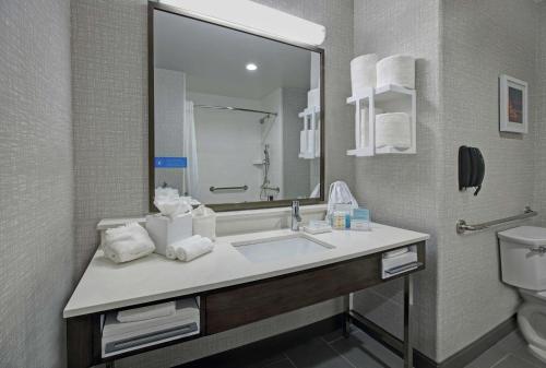 een badkamer met een wastafel, een toilet en een spiegel bij Hampton Inn Weslaco in Weslaco