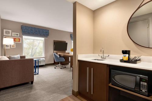 a bathroom with a sink and a living room at Hampton Inn & Suites Ocean City West in Ocean City