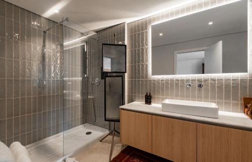 a bathroom with a sink and a shower and a mirror at Casa As Macieiras in Bolembre de Baixo