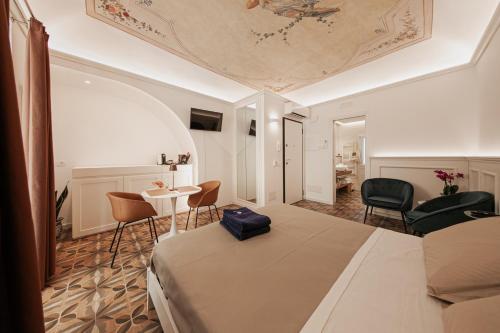 um quarto com uma cama, uma mesa e cadeiras em I Mori Apartments em Cefalù