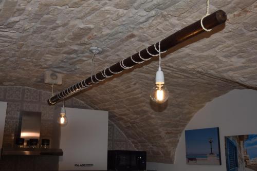 ein langes Rohr, das von einer Decke mit Lichtern hängt in der Unterkunft Le Chiavi di San Pietro in Noci