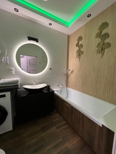 W łazience znajduje się wanna, umywalka i lustro. w obiekcie Towarowa - Milionowa 39 Check-in 24H w Poznaniu