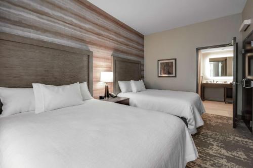 Postel nebo postele na pokoji v ubytování Embassy Suites by Hilton Jonesboro Red Wolf Convention Center