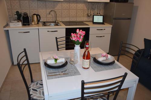 eine Küche mit einem Tisch mit 2 Tellern und Blumen darauf in der Unterkunft Le Chiavi di San Pietro in Noci
